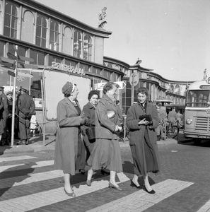839100 Afbeelding van een groepje dames op de oversteekplaats voor voetgangers op het Stationsplein te Utrecht.